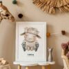Stylish and modern scandinavian newborn baby interior with mock up photo frame on the small table. Toys, sofa, plush animal and hanging cotton colorful balls. Beige wall. Design home staging. Template